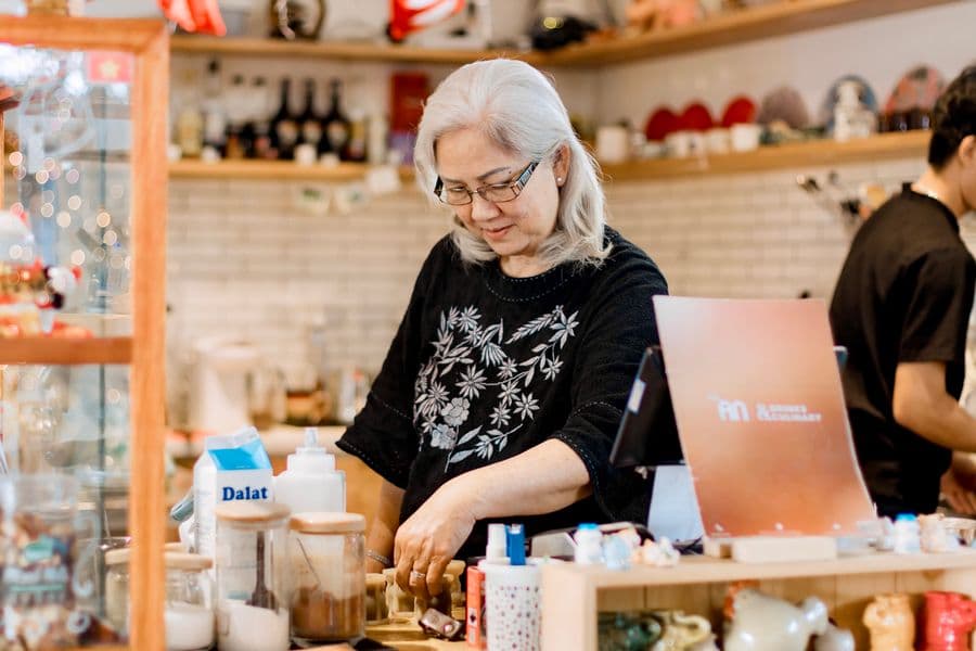 Owner working behind the counter of a small coffee shop
